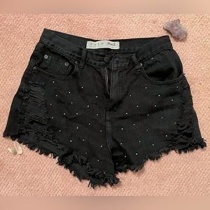 Distressed, blessed, + bedazzled dark gray/black denim shorts.